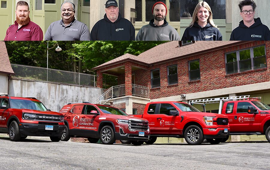 A group of people in branded clothing are shown above four company vehicles parked in front of a building.