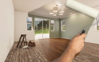 A freshly painted green wall being painted over by a hand holding a roller brush; an empty room with tools and ladder visible.