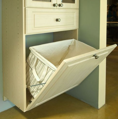 A built-in laundry hamper with a pull-down door integrated into a wooden cabinet, showcasing a cloth bin inside.