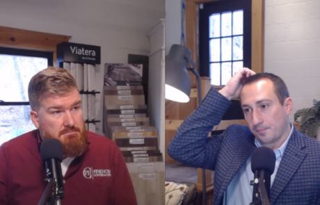Two men having a podcast discussion in a room with fabric samples and house plants; one appears to be thinking, the other attentive.