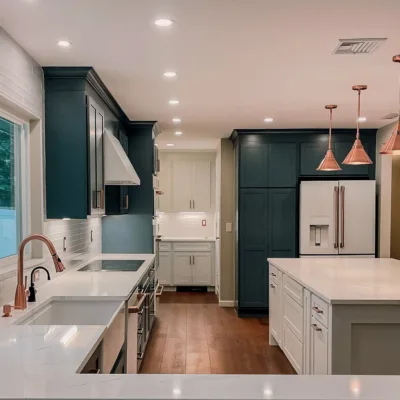 Modern kitchen with white countertops, dark cabinets, copper fixtures, hardwood floors, and recessed lighting.
