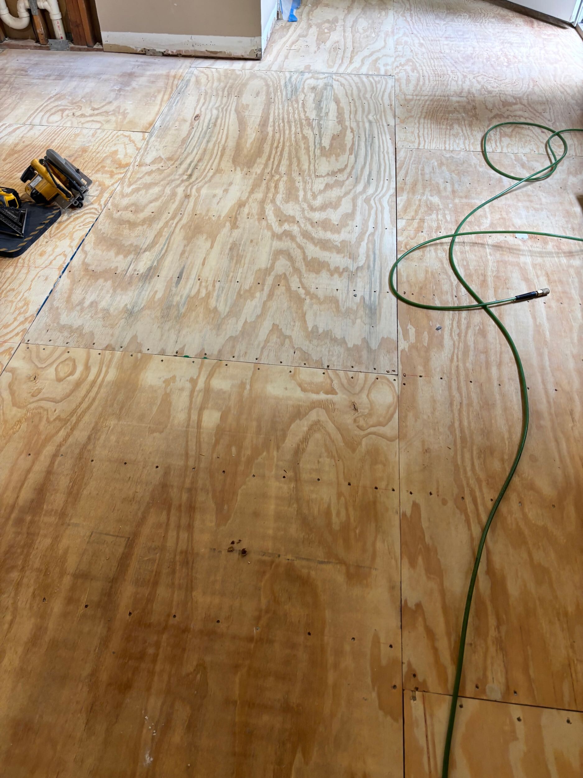 New plywood subfloor installed during a kitchen renovation